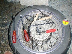 外したリアホイールの上に並べたタイヤ交換の道具の写真