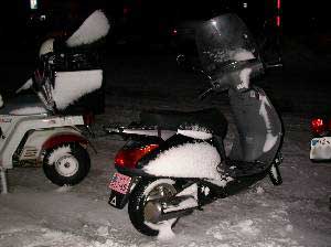 雪にまみれた小型スクーターの写真