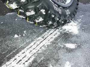 アイスバーンを削り取っている大型バイクのスパイクタイヤの写真